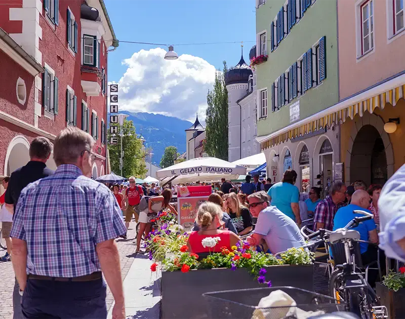Mann geht durch die Stadt Lienz an einem gemütlichen Strassencafe vorbei