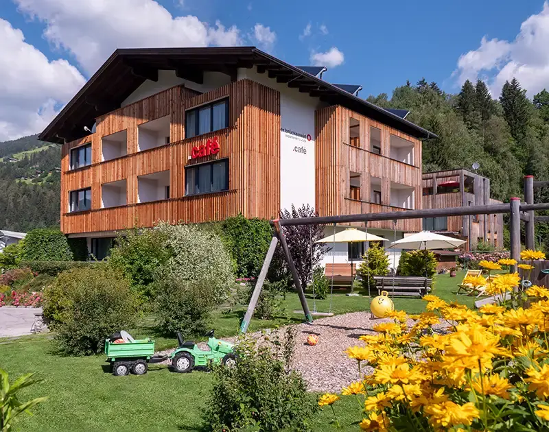 Fassade Haus Brueckenwirt mit Terrasse und Bepflanzung
