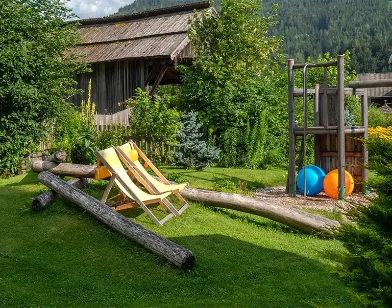 Garten mit Spielplatz mit Schaukel und Liegestühlen