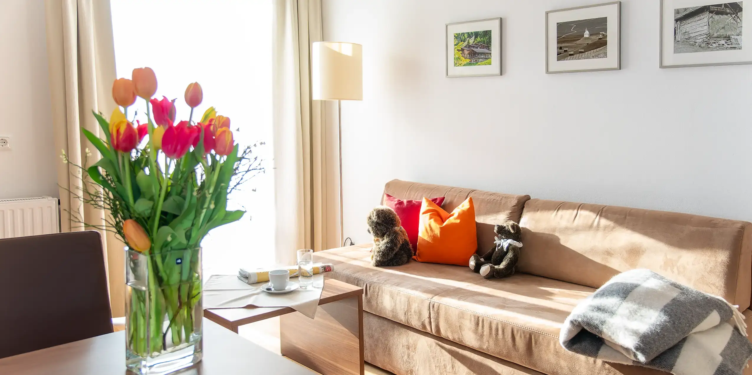 Appartamento junior con divano, un colorato mazzo di fiori in primo piano