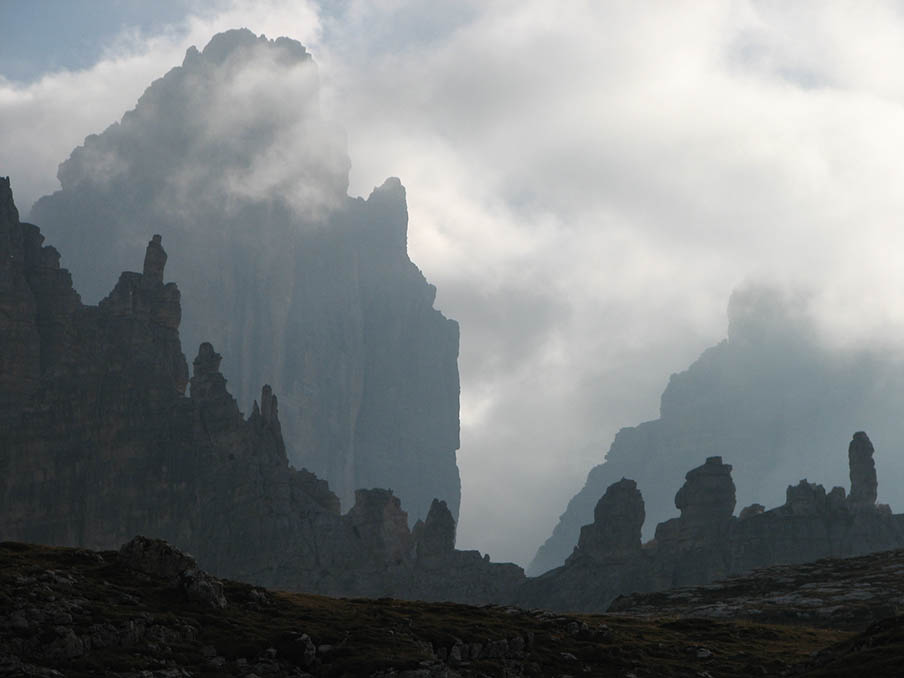 Die Gipfel der Drei Zinnen sind von Nebelschwaden umgeben und wirken wie Berggeister.