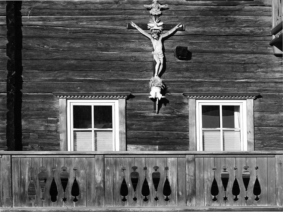 Kruzefix über dem Balkon auf Holzhaus