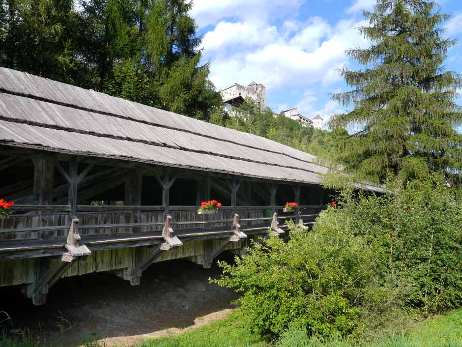 im Vordergrund liegt die Punbrugge, eine historische Brücke über den Villgrater Bach. Darüber am Berg die Burg Heinfels.